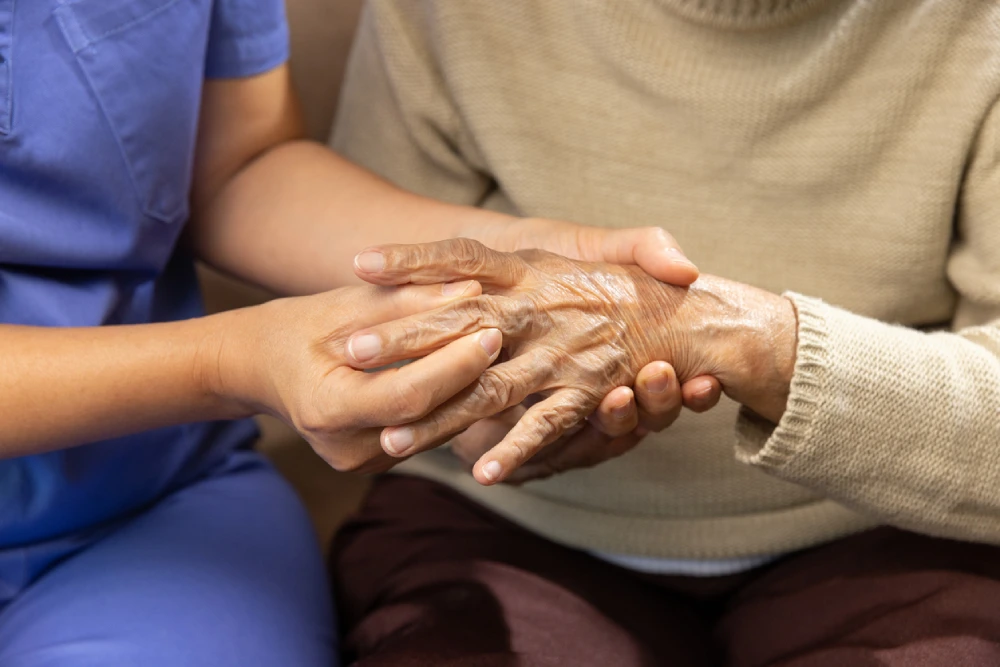 person having arthritis symptoms in their hands checked by a healthcare professional
