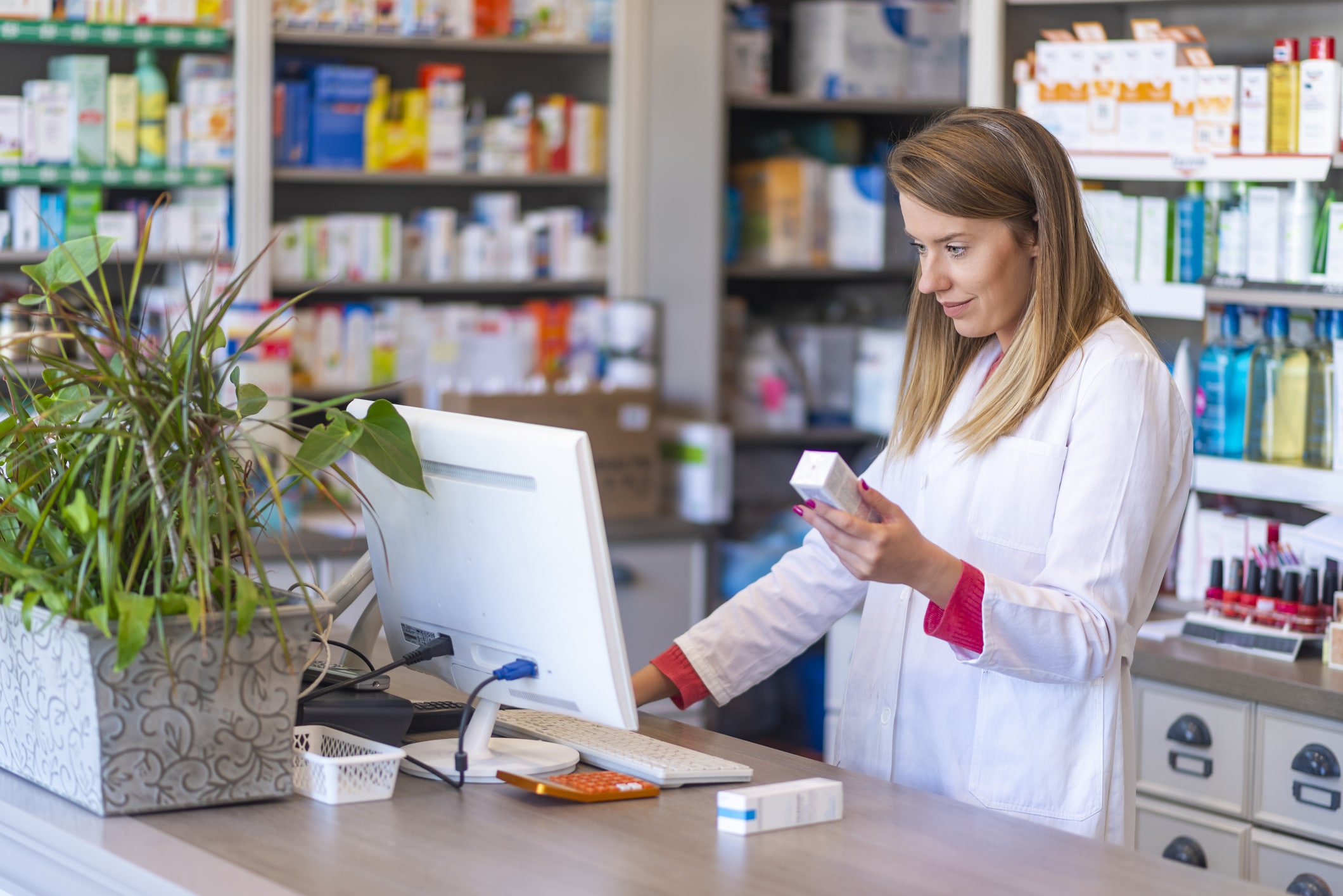 Female pharmacist checking a prescription transfer on the computer