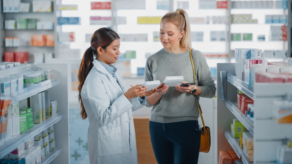 A blonde woman talking to her local PharmaChoice pharmacist about lupus management options.