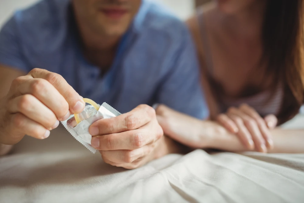 man taking out a condom for chlamydia prevention