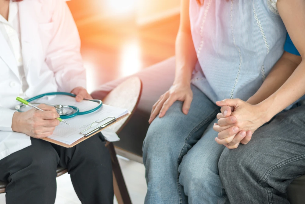 Couple talking to doctor about chlamydia symptoms and chlamydia treatment