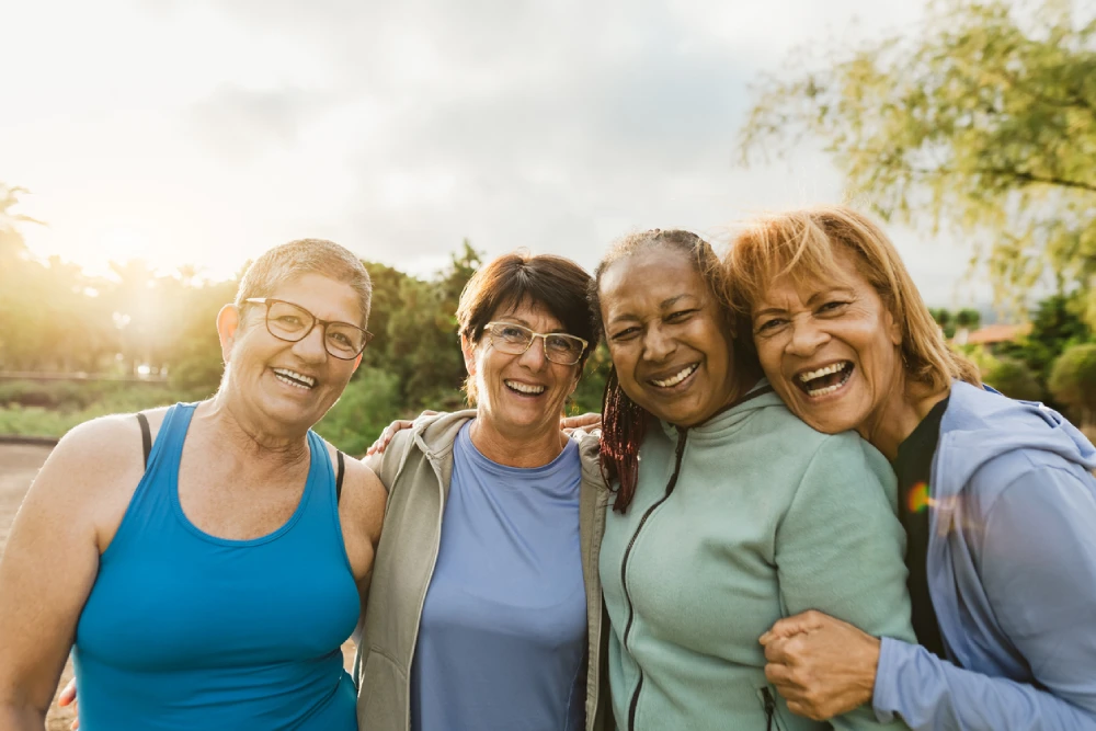 group of women smiling at the camera - staying social, a key measure in supporting women's brain health