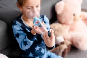 child using an inhaler with a spacer device for asthma management