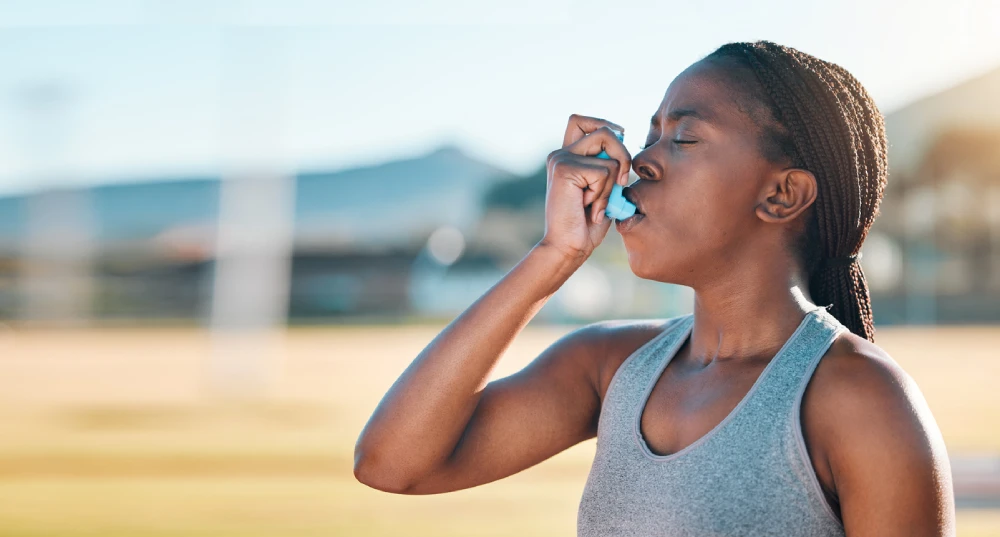 woman using an inhaler before exercising