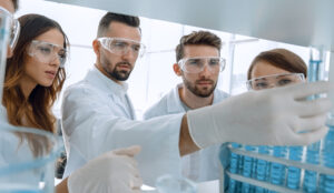 Background image is a group of microbiologists studying the liqu