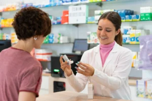 pharmacist showing patient how to use their inhaler for asthma management