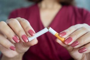 Woman hand breaking cigarette stop smoking concept jpg