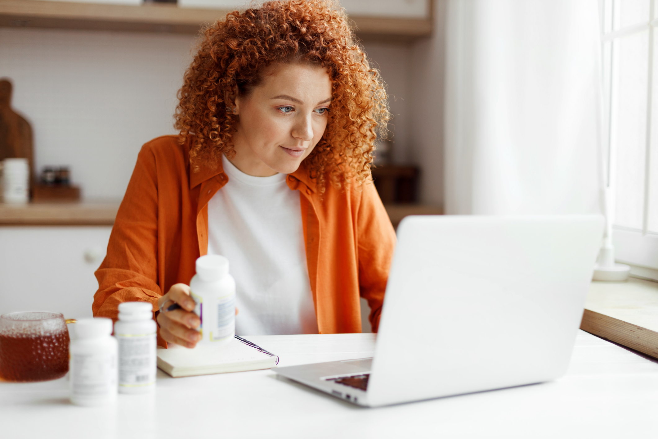 A woman researches her medications on her laptop.